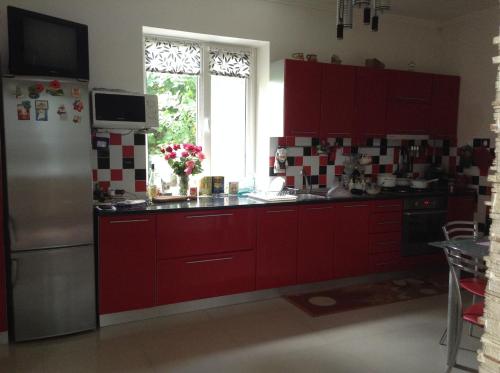 a kitchen with red cabinets and a stainless steel refrigerator at Homestay Khomenko in Perechin