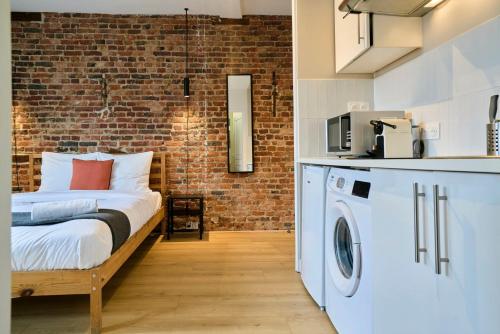 ein Zimmer mit einem Bett und einer Waschmaschine in der Unterkunft Old Town - Nice studio in Lille