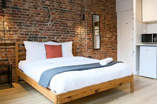 ein Bett in einem Zimmer mit einer Backsteinwand in der Unterkunft Old Town - Nice studio in Lille