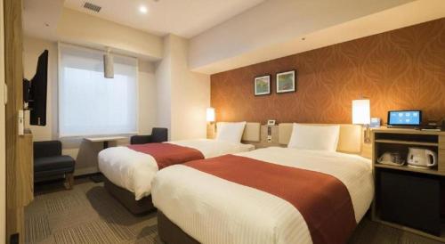 a hotel room with two beds and a television at KEIKYU EX INN Keikyu Kawasaki-Station in Kawasaki