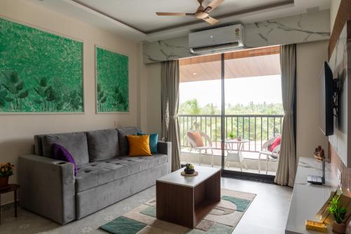 a living room with a couch and a balcony at 1bhk with Pool & Wifi near Candolim beach in Nerul