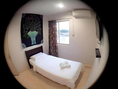 a bedroom with a white bed and a window at De Chukai Hotel in Cukai