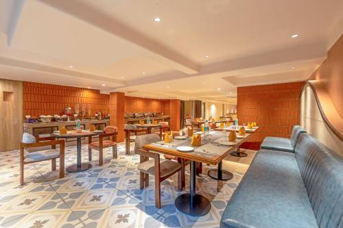 a restaurant with tables and chairs and a cafeteria at Sterling Rampath Ayodhya in Ayodhya