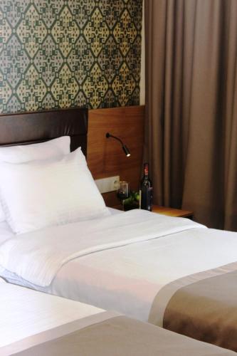 a bedroom with two beds and a table with a lamp at Hotel Panorama Gareji in Sagarejo