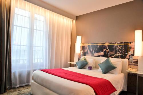 パリにあるメルキュール パリ ガル ドゥ レストのベッドルーム1室(赤毛布付きの大型ベッド1台付)
