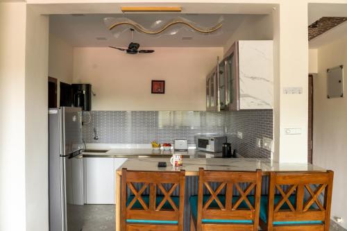 a kitchen with a counter and a refrigerator at 1bhk with Pool & Wifi near Candolim beach in Nerul