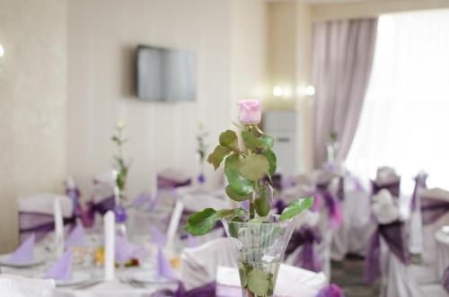 a vase with a rose in it on a table at Bacolux Craiovita, Craiova in Craiova
