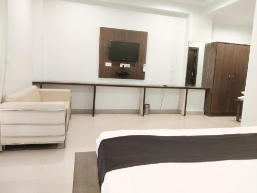 a room with a bed and a tv on the wall at Hotel Yamunotri Retreat, Rishikesh in Rishīkesh