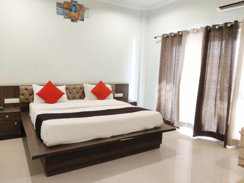 a bedroom with a large bed with red pillows at Hotel Yamunotri Retreat, Rishikesh in Rishīkesh