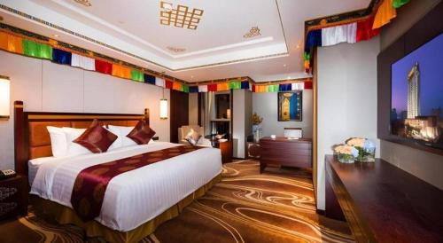 a hotel room with a large bed and a television at New Century Grand Hotel Xi'an Xizang Building in Xi'an