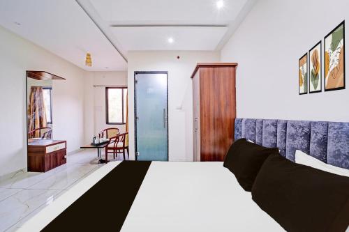 a bedroom with a bed and a table and a chair at Super Townhouse LIG Main Road Indore in Indore