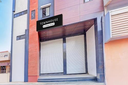 a building with a garage with a sign on it at Super Townhouse LIG Main Road Indore in Indore