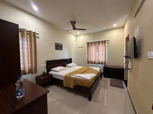 a bedroom with a bed and a flat screen tv at SPICE HOMESTAY Apartment in Singānallūr