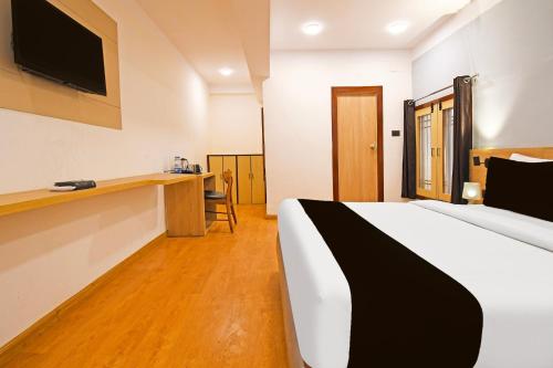 a hotel room with a bed and a desk at Super Townhouse Hill Cart Road Siliguri in Siliguri