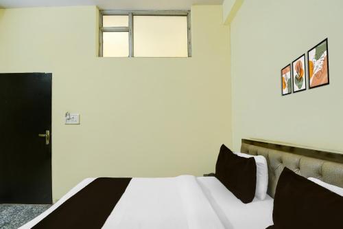 a bedroom with a white bed with black pillows at Super Collection O Sunder Nagar Golvyas Formerly Hotel Vanshil in Jaipur