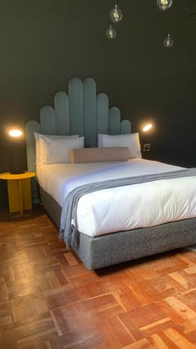 Modern Studio في كيب تاون: غرفة نوم بسرير كبير مع لوح رأس أزرق