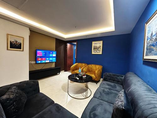a living room with a couch and a tv at Gold Crest Apartments Luxurious in Lahore