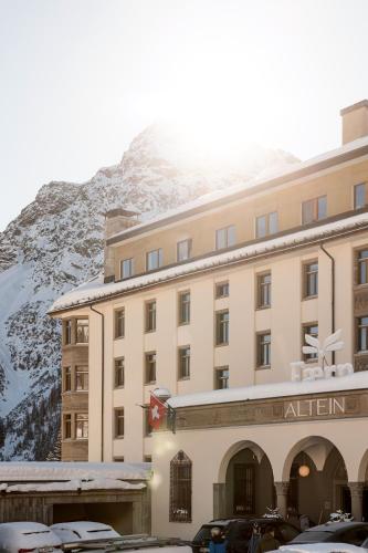a hotel with a snow covered mountain in the background at Hotel Altein Arosa, a Faern Collection Resort in Arosa