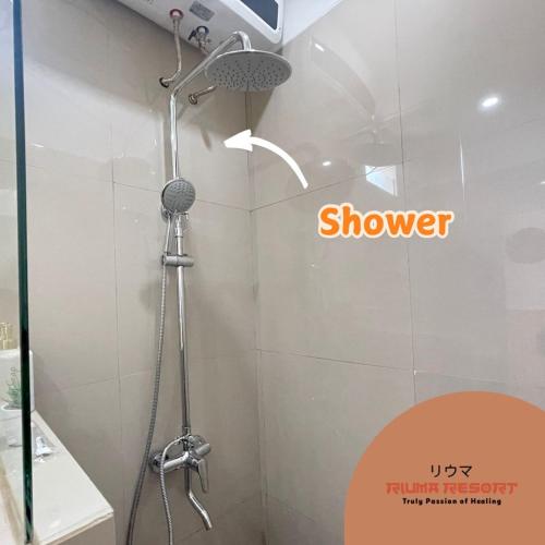 a shower in a bathroom with a sign that reads shower at Riuma Resort in Karangploso