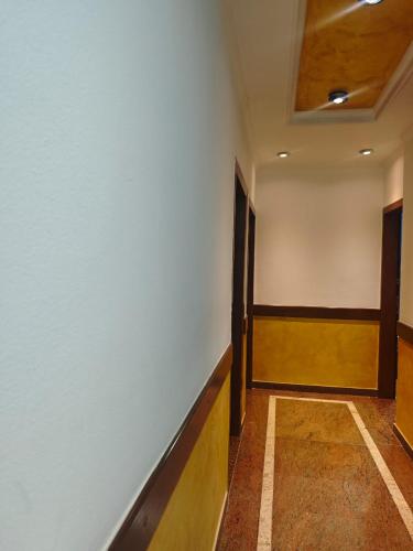 a hallway with a white wall and a wooden floor at Hotel Artist in Tirana