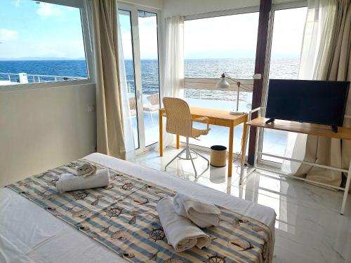 a bedroom with a bed and a desk with a computer at Seafront Panorama Penthouse in Chios
