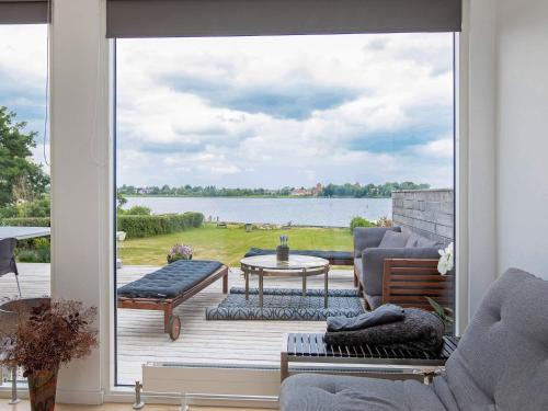 a screened in porch with a view of the water at 8 person holiday home in Præstø in Præstø