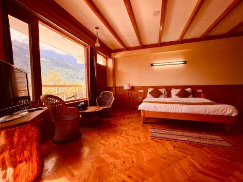 a bedroom with a bed and a large window at Hotel Valley of Vashisht - Scenic River & Mountain View Hotel in Manali in Manāli