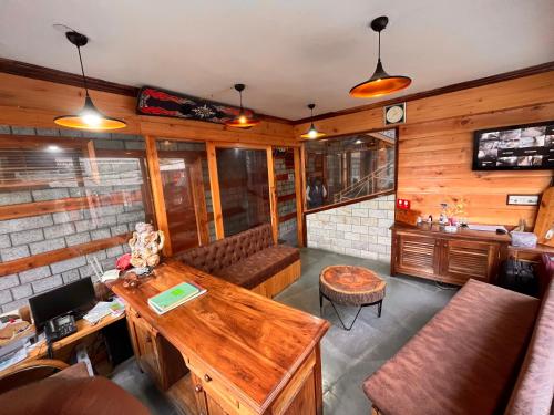 a living room with a couch and a table at Hotel Valley of Vashisht - Scenic River & Mountain View Hotel in Manali in Manāli