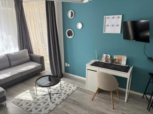 Una sala de estar con un sofá y un escritorio. en ÁTRIUM Apartman Kaposvár, en Kaposvár