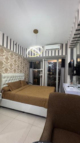 a bedroom with a bed and a couch in it at Apartemen Anderson 28 1 Pakuwon mall Luxury Studio Apartment Connecting Mall, Pool & City View in Surabaya