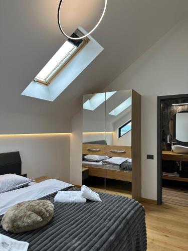 a bedroom with a bed with a mirror and a skylight at Altfel Bran Chalet 2 in Bran