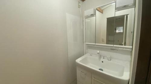 a white bathroom with a sink and a mirror at 一宿一景一生縁-千葉県市原市小谷田店 in Ichihara