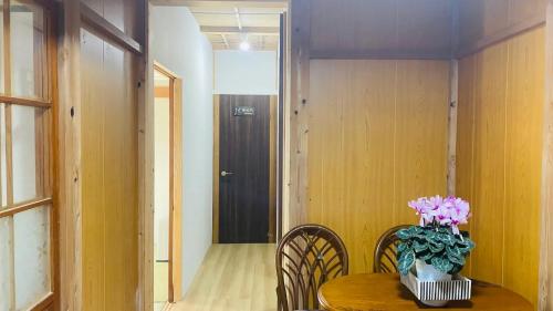 a dining room table with a vase of flowers on it at 一宿一景一生縁-千葉県市原市小谷田店 in Ichihara