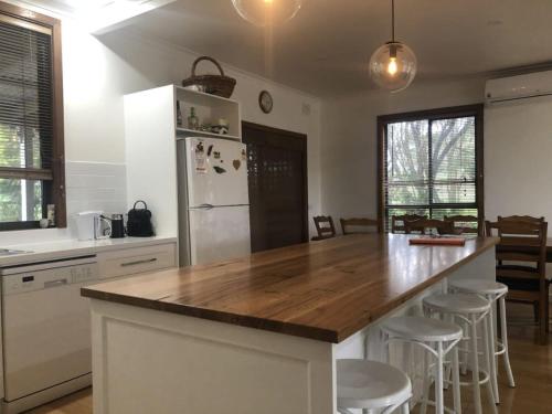 cocina con encimera de madera y nevera en Mataluka at Fish Creek, en Fish Creek