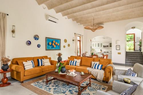 ein Wohnzimmer mit zwei Sofas und einem Tisch in der Unterkunft La Selva - 4BHK Luxury Villa in Assagao with Private Pool near Cafés & Soro Pub in Assagao
