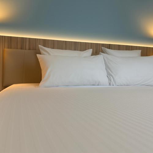 a large white bed with white pillows on it at Campanile Reims Centre - Cathedrale in Reims