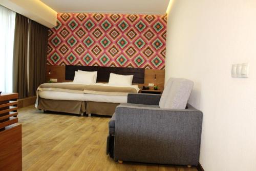 a hotel room with a bed and a chair at Hotel Panorama Gareji in Sagarejo