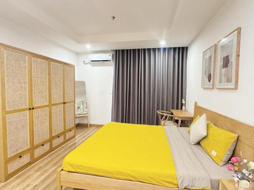 a bedroom with a yellow bed in a room at TMS Quy Nhơn - Hupa Apartment View Biển in Quy Nhon