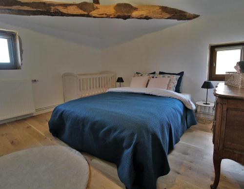 a bedroom with a bed with a blue blanket at Maison Forte DES GRANDS MAISONS in Cogny