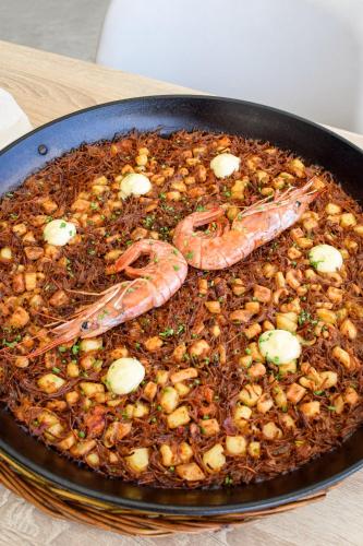 a pan full of food with shrimp and other ingredients at Hotel Horitzó by Pierre & Vacances in Blanes