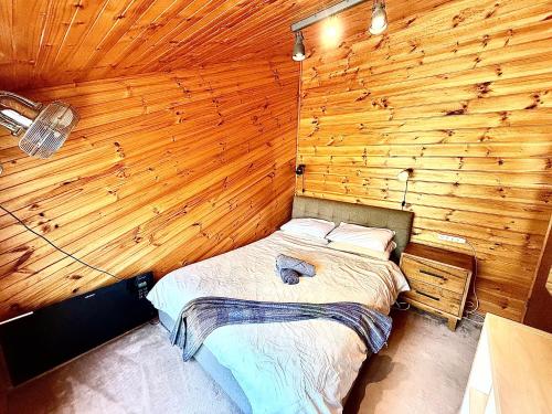 a bedroom with a bed in a wooden wall at Grampians Bush Retreat in Halls Gap