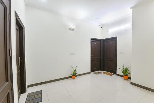 an empty hallway with two doors and potted plants at FabHotel Golf Luxury in Gurgaon