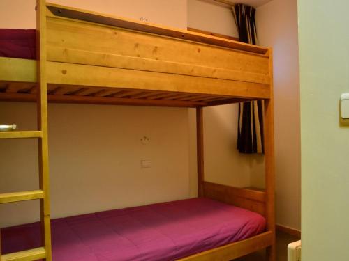 a bedroom with two bunk beds with purple sheets at Appartement cosy à Montchavin, ski au pied, 2 pièces, terrasse, parking inclus, proche commerces. - FR-1-329-11 in Bellentre