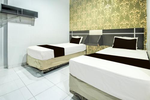 Ένα ή περισσότερα κρεβάτια σε δωμάτιο στο Hotel O Makassar near Mall Panakukang formerly Hotel Lucky Inn Makassar