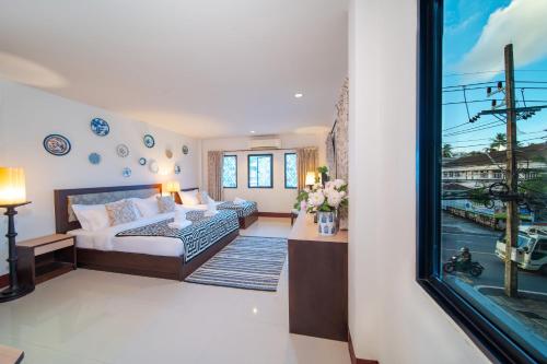 a living room with a bed and a window at Nyonya Maison Boutique Hotel Phuket Old Town in Phuket Town