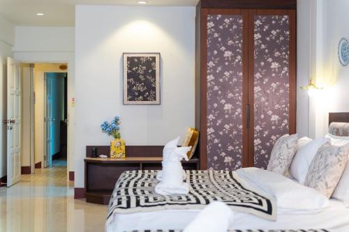 a bedroom with a bed and a table with a book at Nyonya Maison Boutique Hotel Phuket Old Town in Phuket Town
