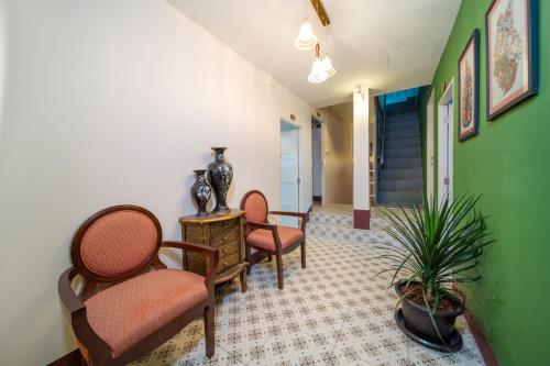 a hallway with chairs and a table and plants at Nyonya Maison Boutique Hotel Phuket Old Town in Phuket Town