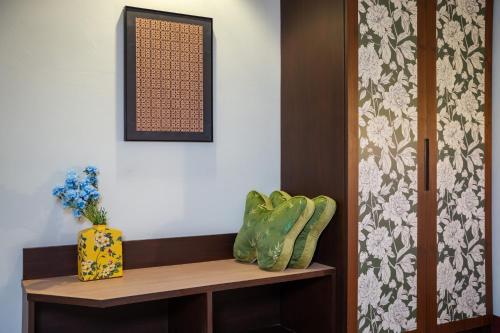 a room with a shelf with a vase on it at Nyonya Maison Boutique Hotel Phuket Old Town in Phuket Town