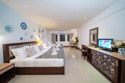 a large bedroom with a large bed and a flat screen tv at Nyonya Maison Boutique Hotel Phuket Old Town in Phuket Town