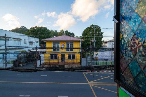 a yellow building on the side of a street at Nyonya Maison Boutique Hotel Phuket Old Town in Phuket Town